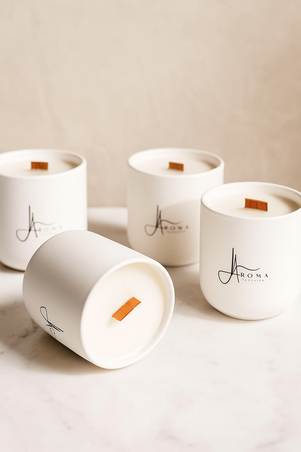 Four white candles with 'Aroma' branding on a light background