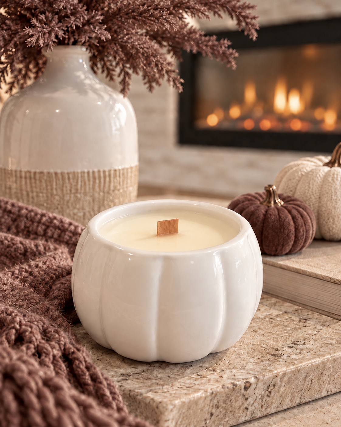 White pumpkin ceramic soy candle with wooden wick in a warm fall setting